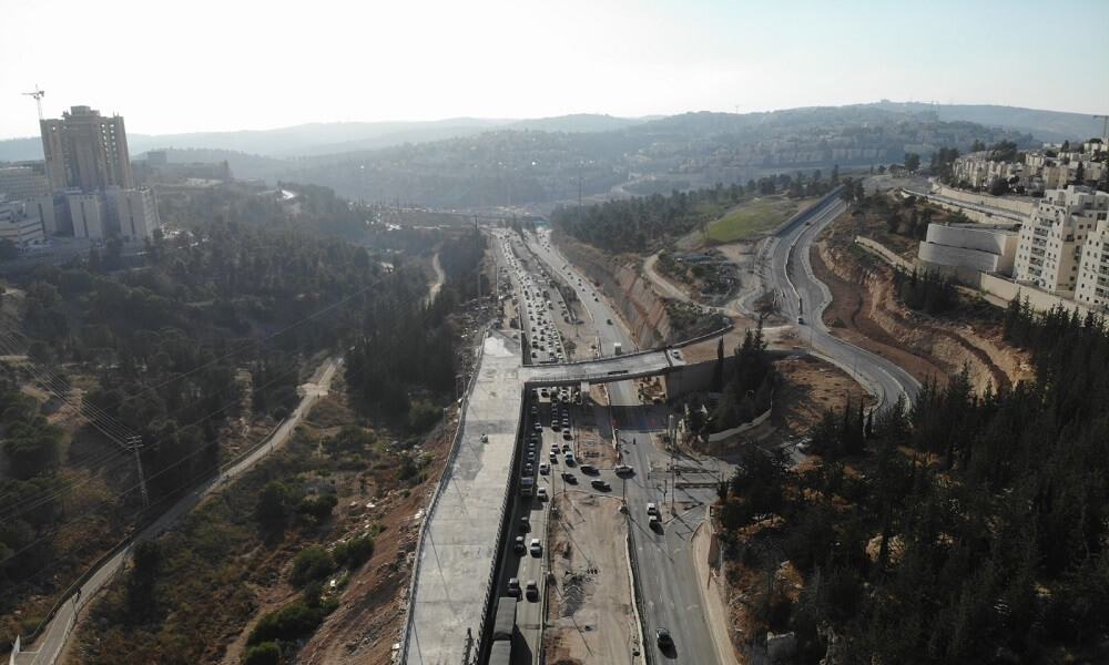 הכביש בערפל, עם גשר, עצים ובניינים מסביב